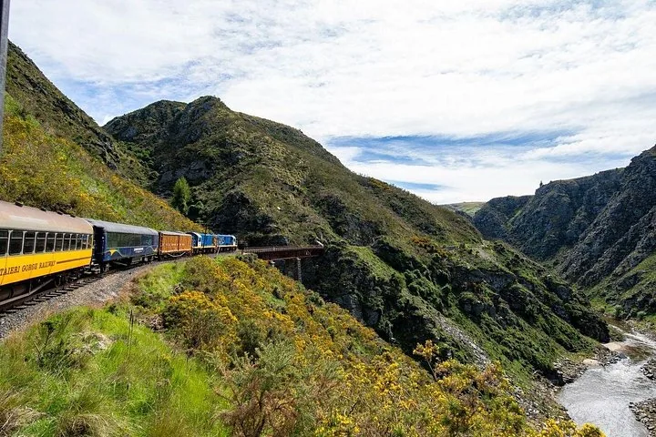 Taieri Gorge Railway train traveling through a rugged, mountainous gorge setting
