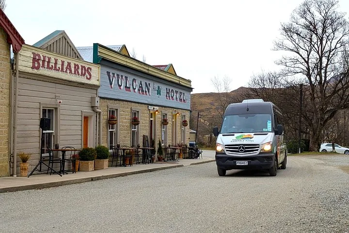 Cheeky Kiwi Travel van driving past the historic Vulcan Hotel building